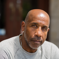 A middle-aged man looks straight on at the camera.