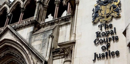 An old building with The Royal Courts of Justice coat of arms on it.